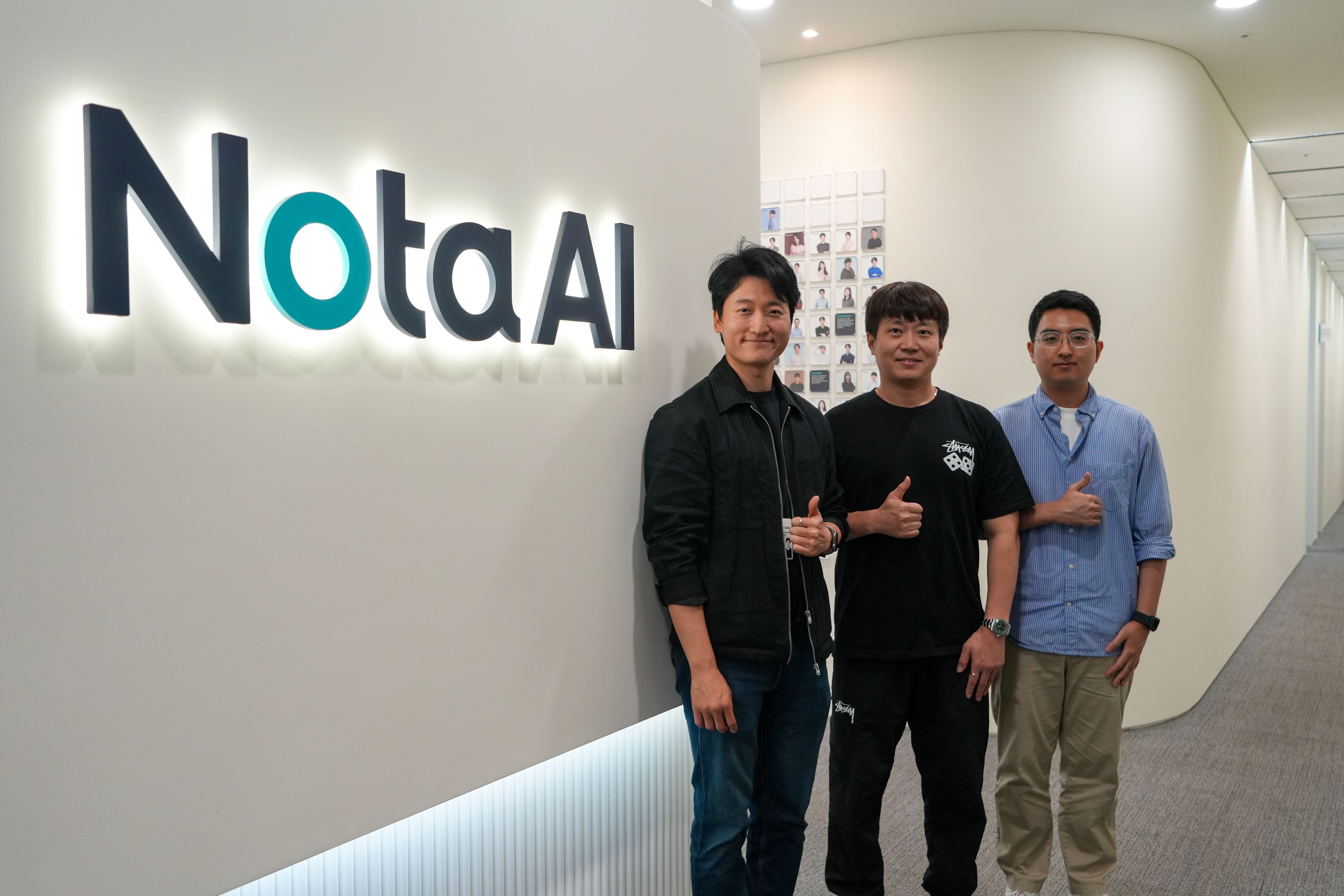 Nota AI personnels standing infront of Nota AI logo.