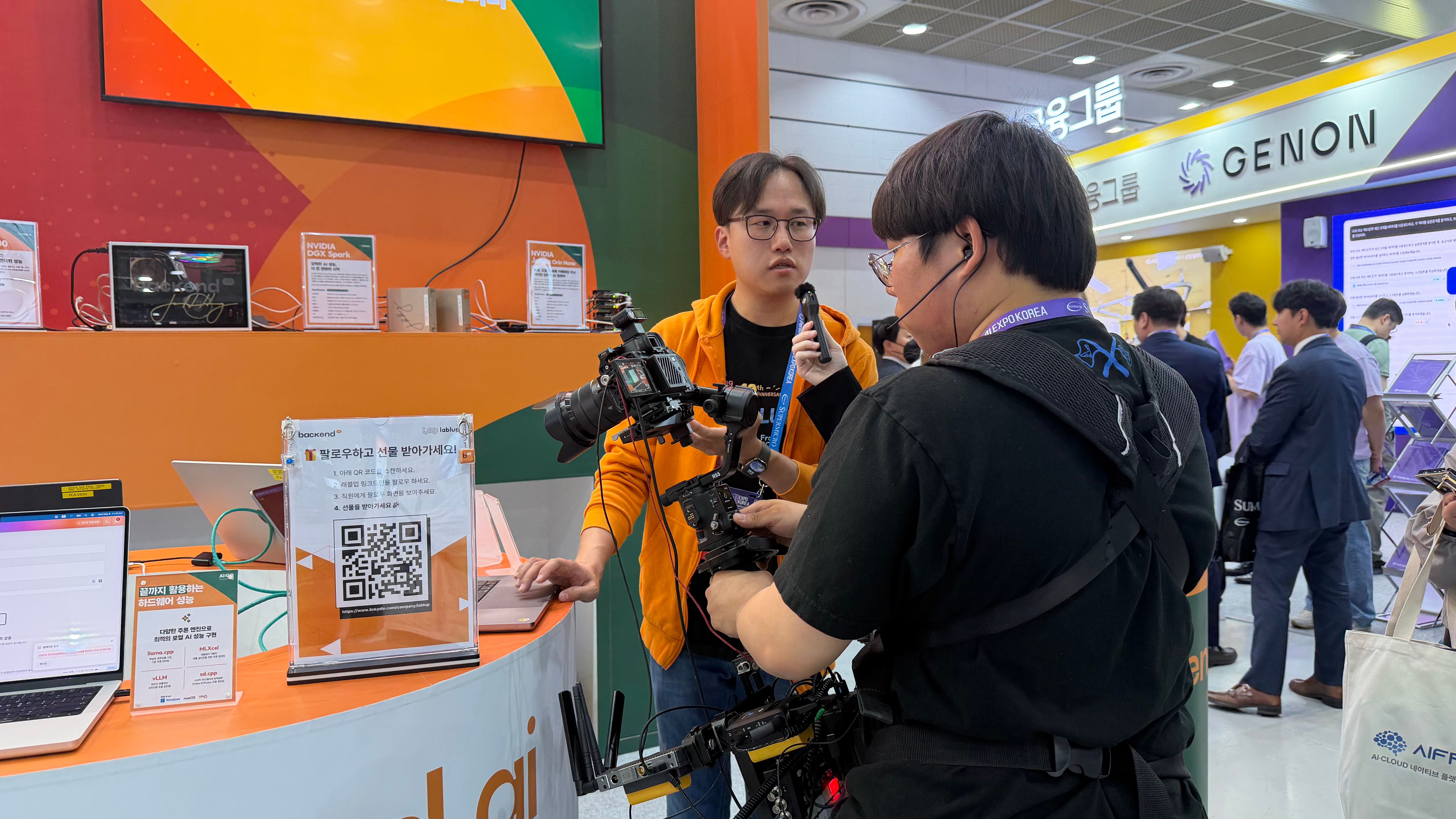 Media crews with cameras and microphones covering the booth.
