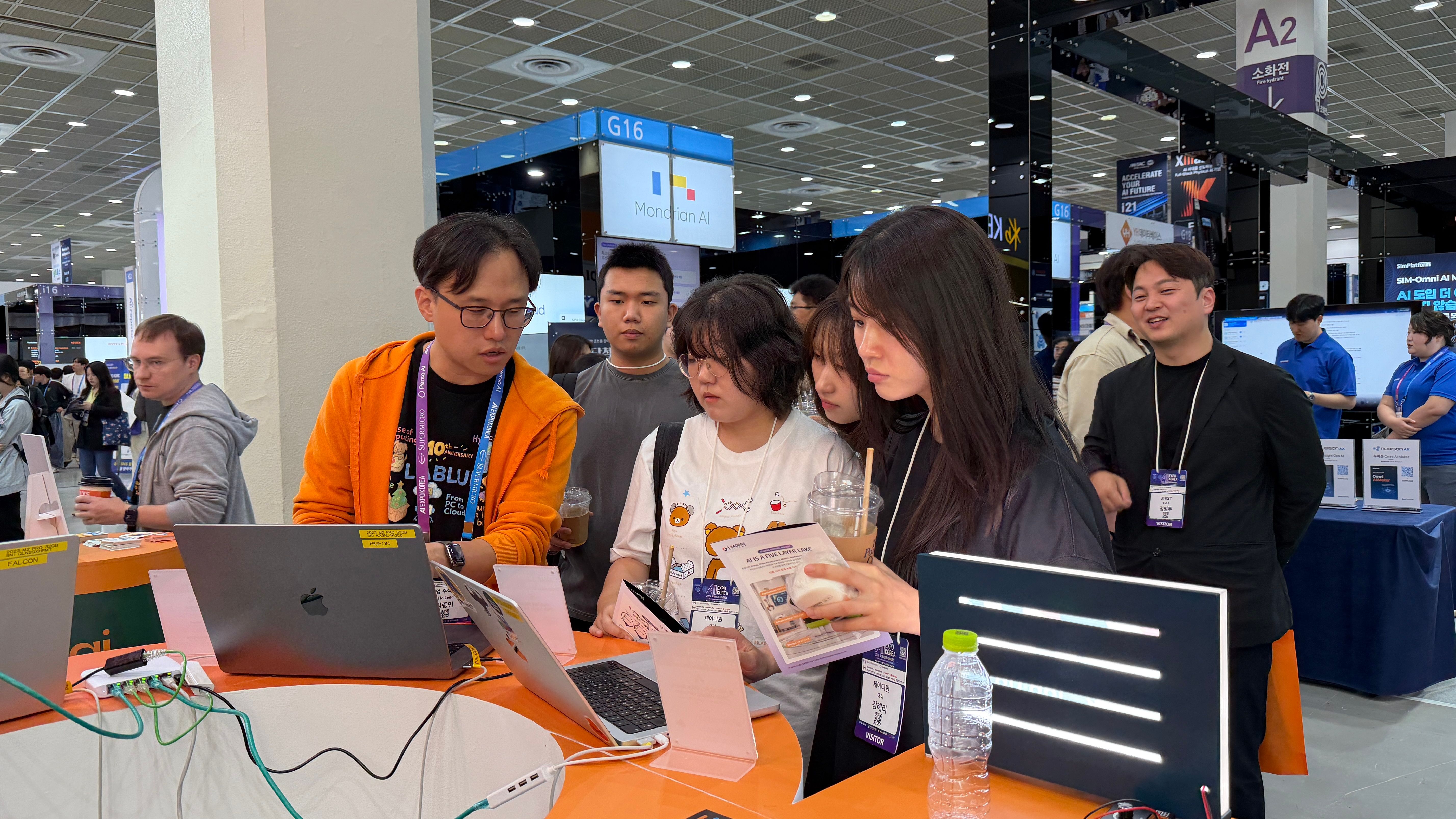 Lablup team members and visitors talking around a demo laptop.